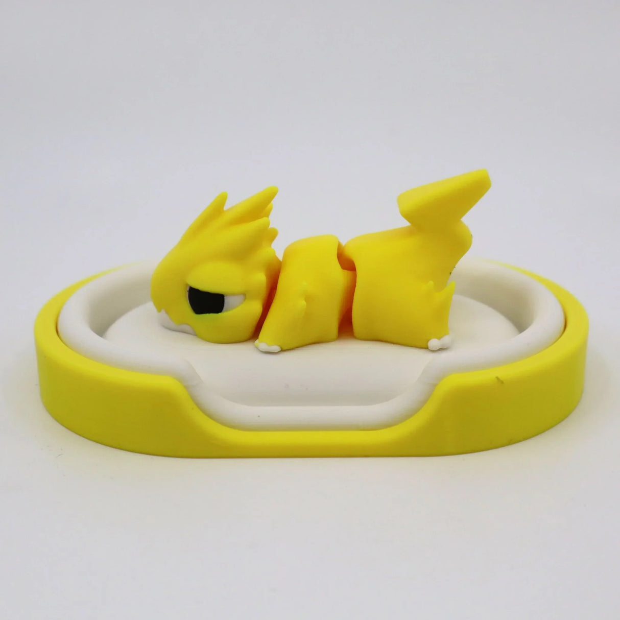 Yellow 3D printed sensory toy animal with flexible joints on a white and yellow tray