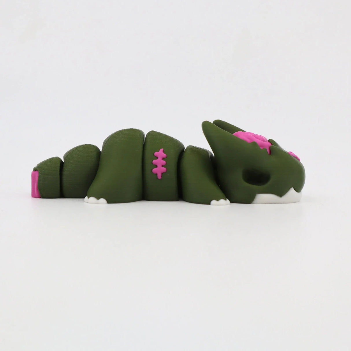 Green 3D printed sensory toy shaped like a segmented dragon with pink and white accents