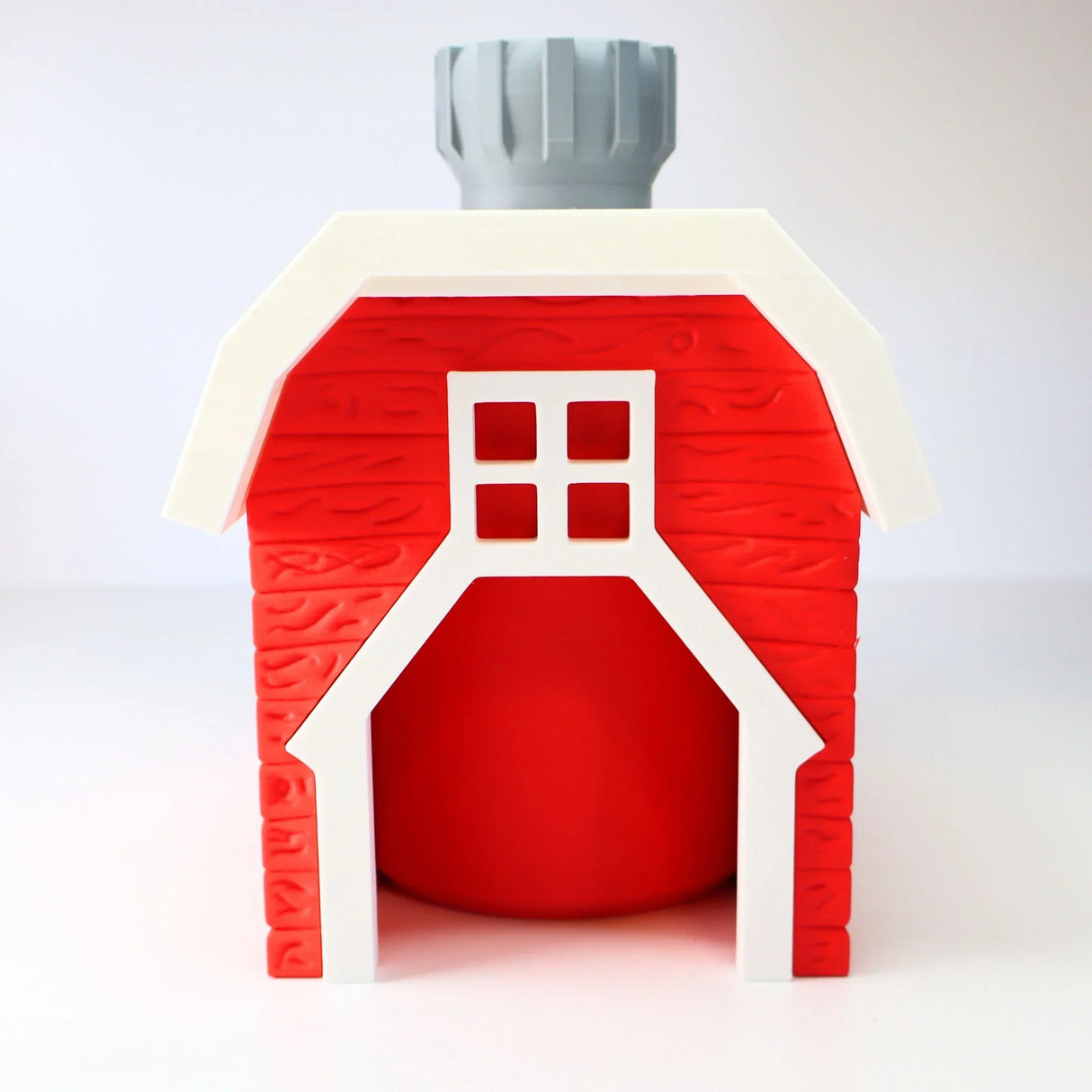 3D printed red barn sensory toy with spinning gray door and white accents on white background