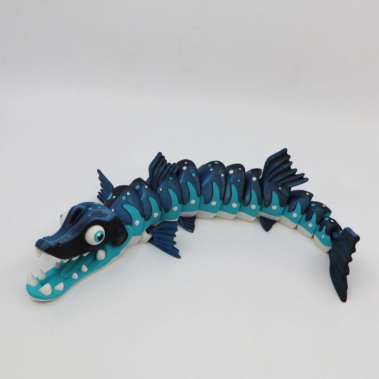 Blue 3D printed sensory toy barracuda with articulated body and white fins