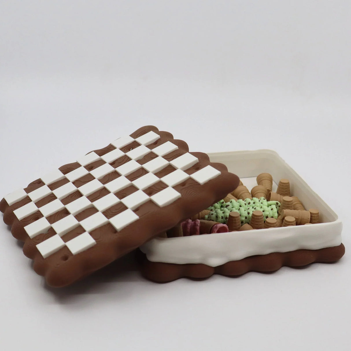 3D printed checkers board cookie box with assorted sensory toy pieces inside