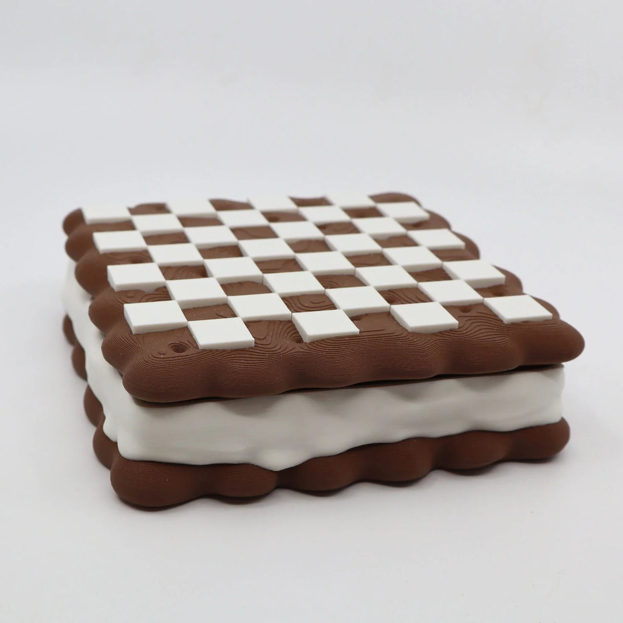3D printed sensory toy shaped like a checkered chocolate sandwich cookie