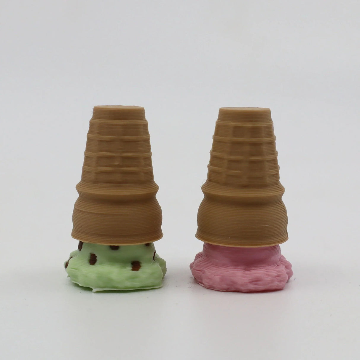 Two 3D printed ice cream cone sensory toys with mint and strawberry base on white background