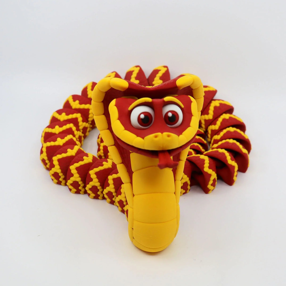 Red and yellow 3D printed flexi cobra sensory toy with cartoon eyes on white background