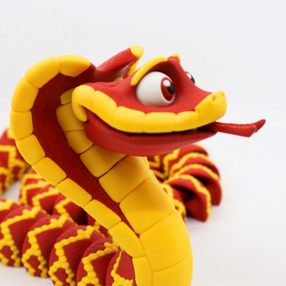 Red and yellow 3D printed snake sensory toy with playful features on a white background