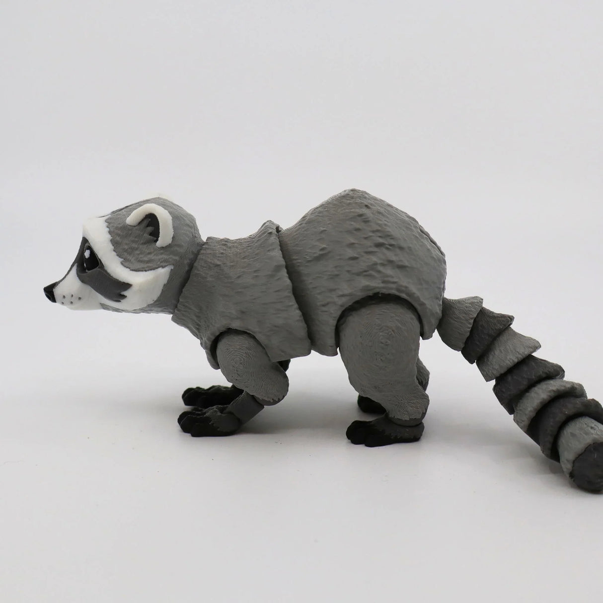 3D printed gray raccoon sensory toy with articulated limbs and textured surface