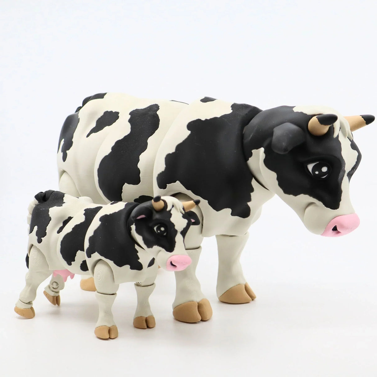 3D printed black and white cow sensory toys, adult and calf, on white background