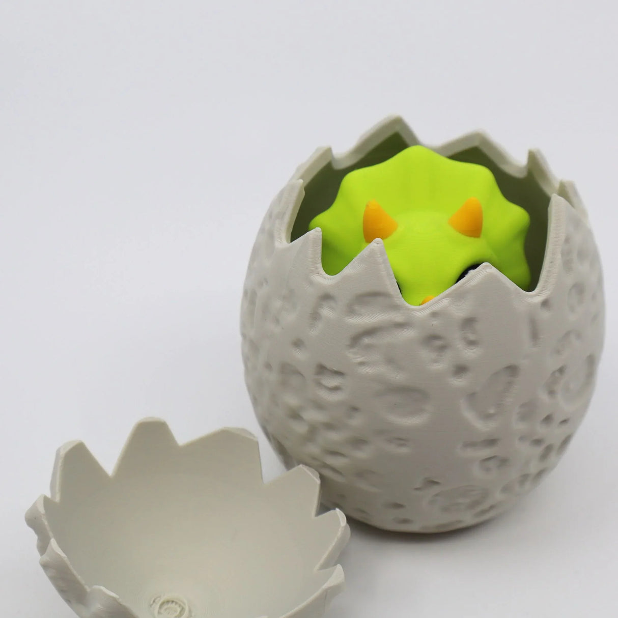 3D printed sensory toy dinosaur hatching from textured egg shell, for kids