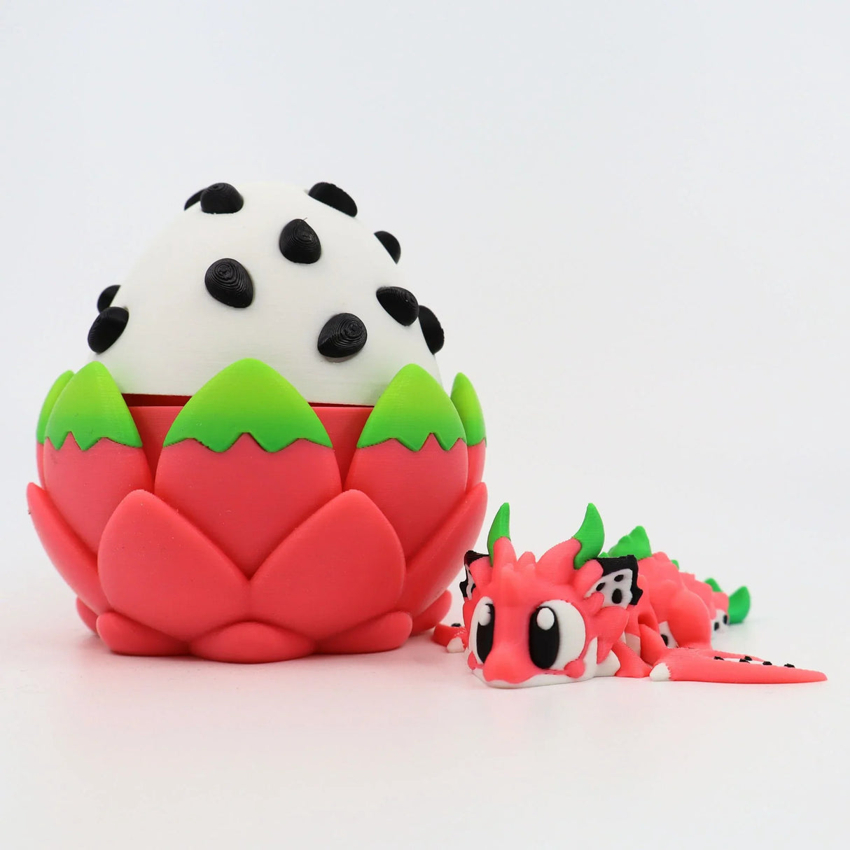 3D printed dragon fruit sensory toy with a cute pink dragon figure beside a dragon fruit egg.