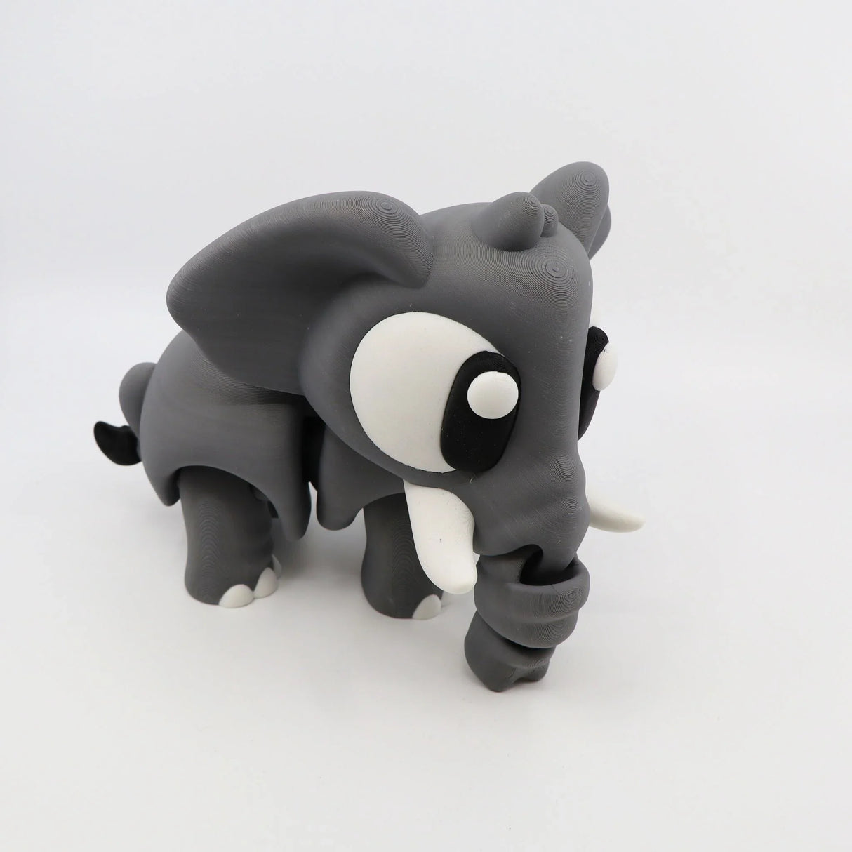 3D printed gray elephant sensory toy with large eyes and curved trunk on white background