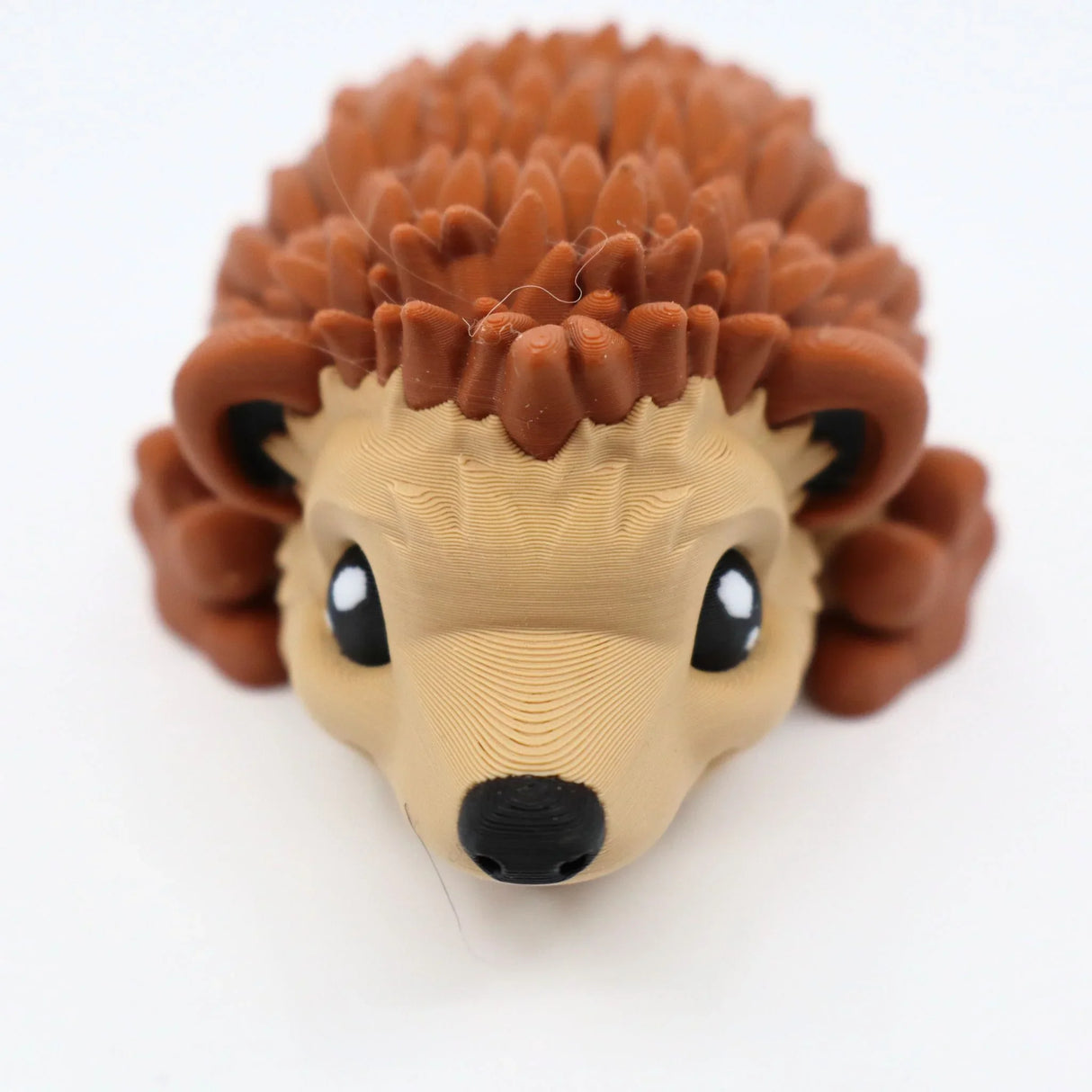 3D printed brown hedgehog sensory toy with textured spikes on white background