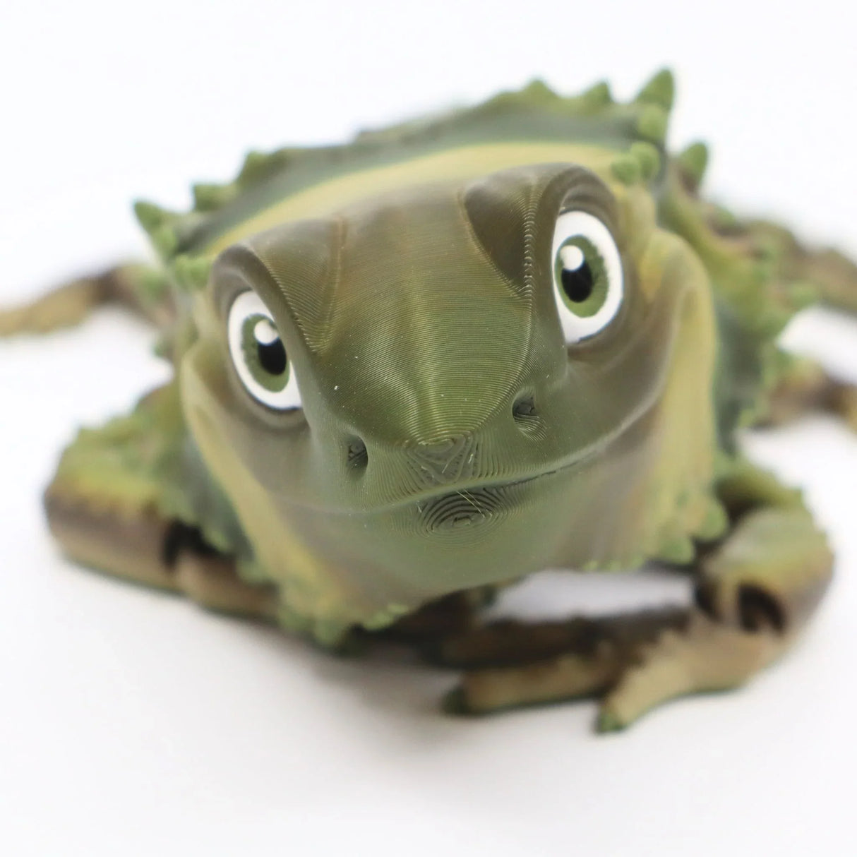 3D printed green sensory toy lizard with textured details on white background