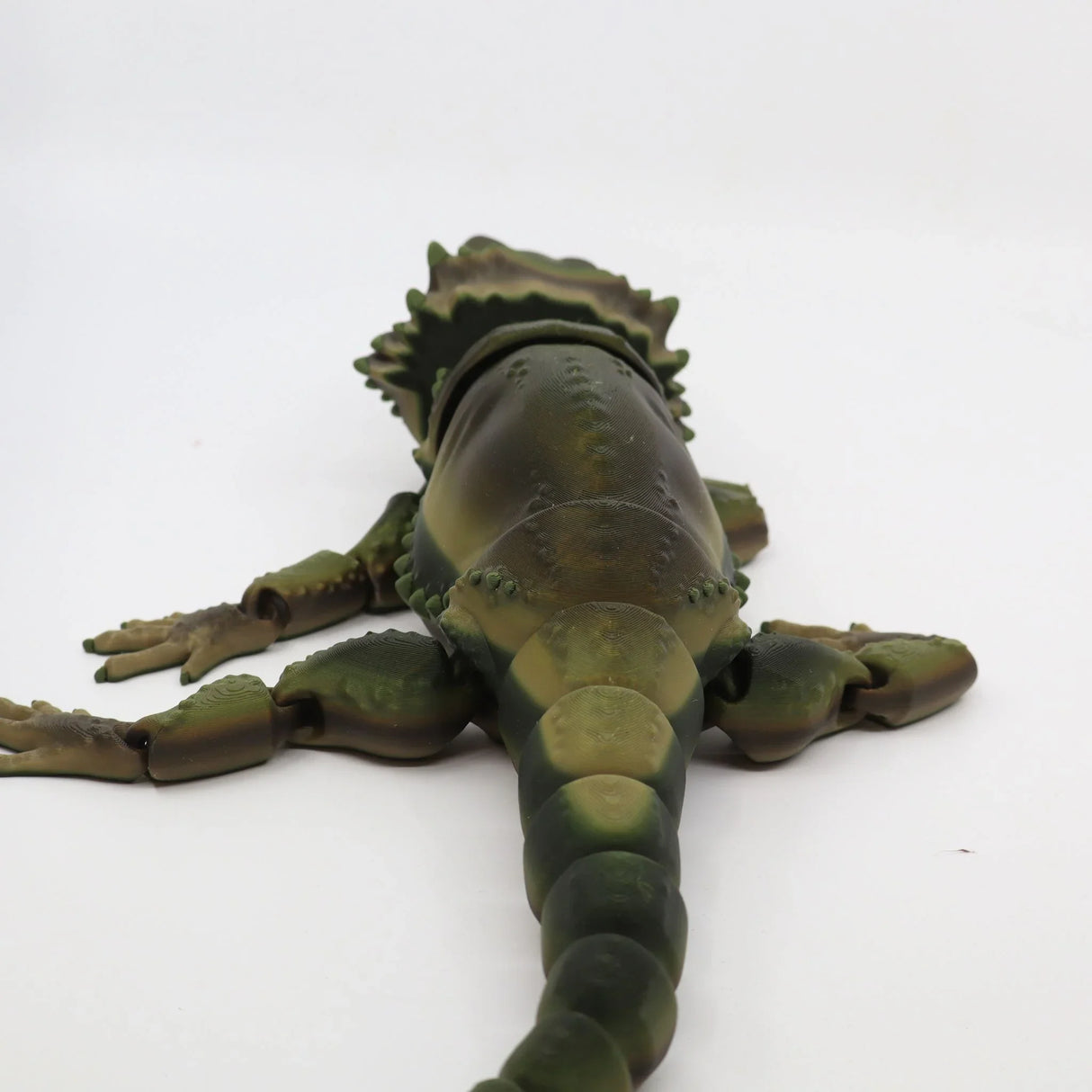3D printed sensory toy lizard with flexible limbs, green and brown, on white background
