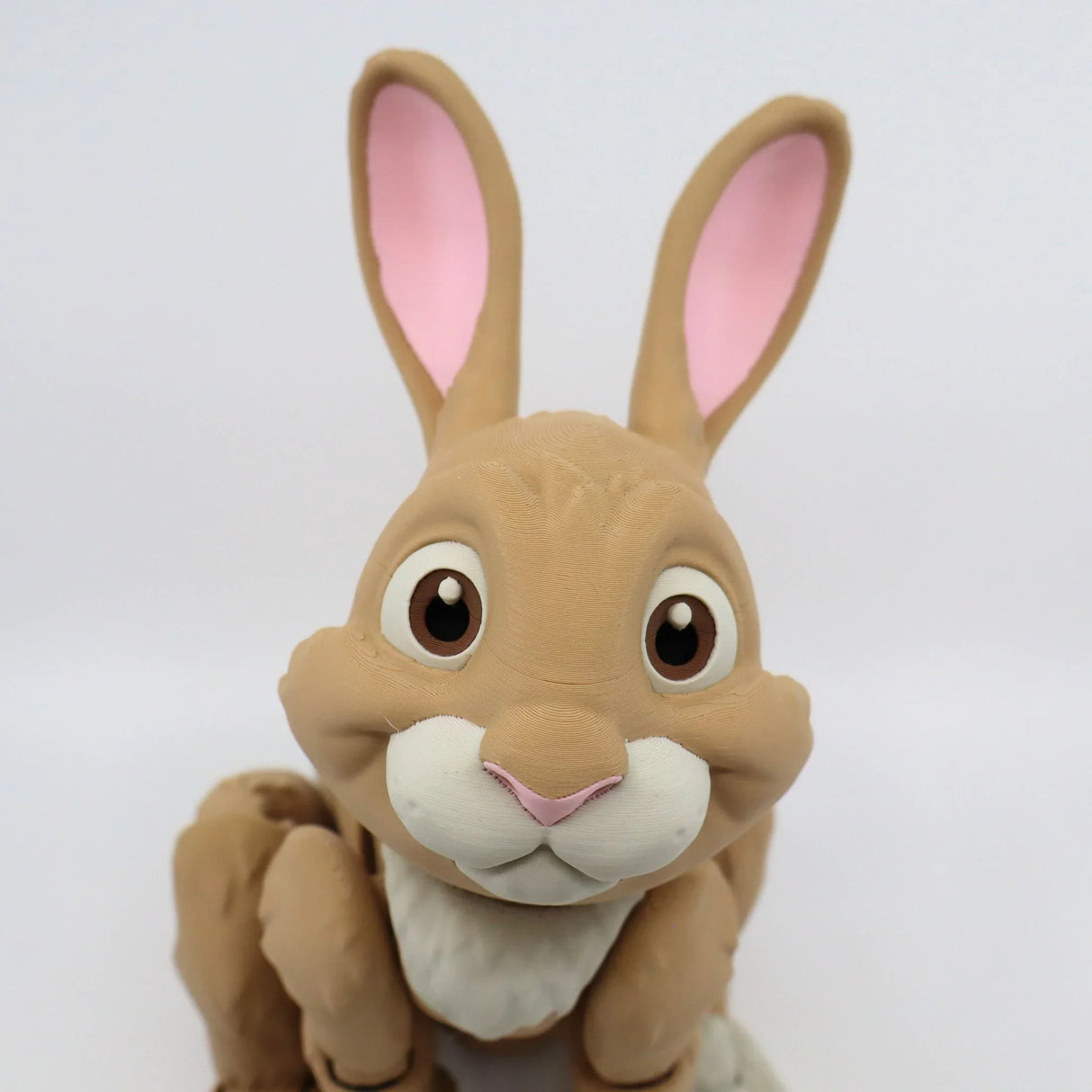 3D printed brown rabbit sensory toy with big eyes and pink ears on white background