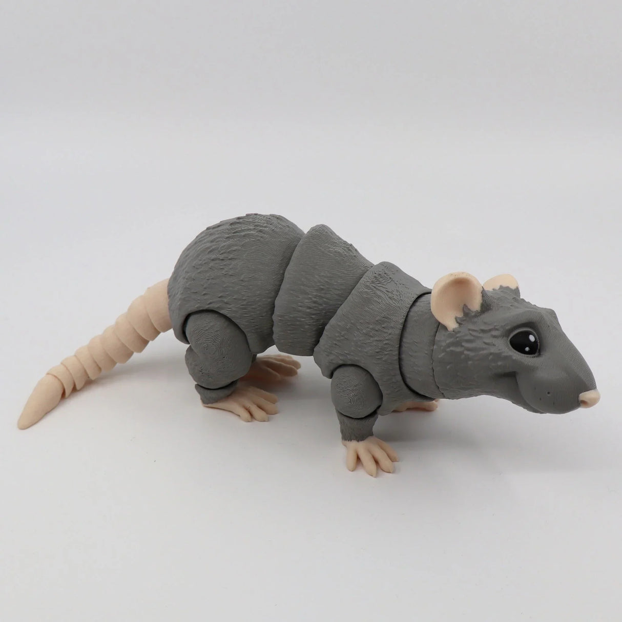 Gray 3D printed sensory rat toy with jointed segments and beige feet, on white background.