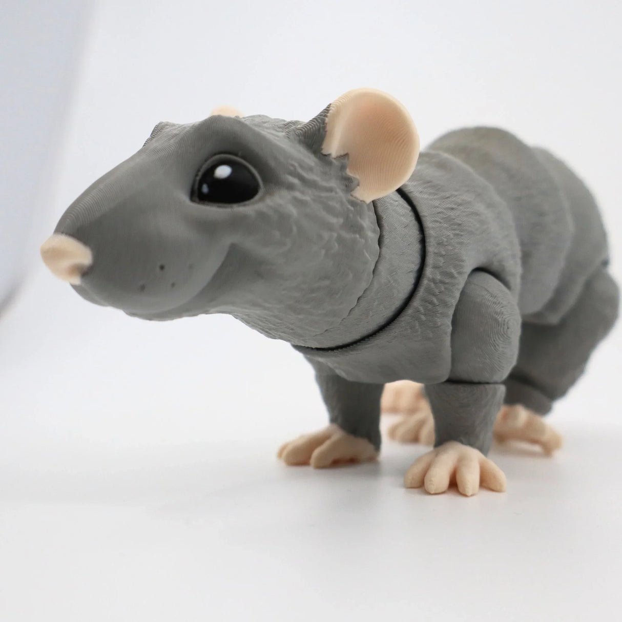 Gray 3D printed sensory rat toy with large eyes and textured detail on a white background