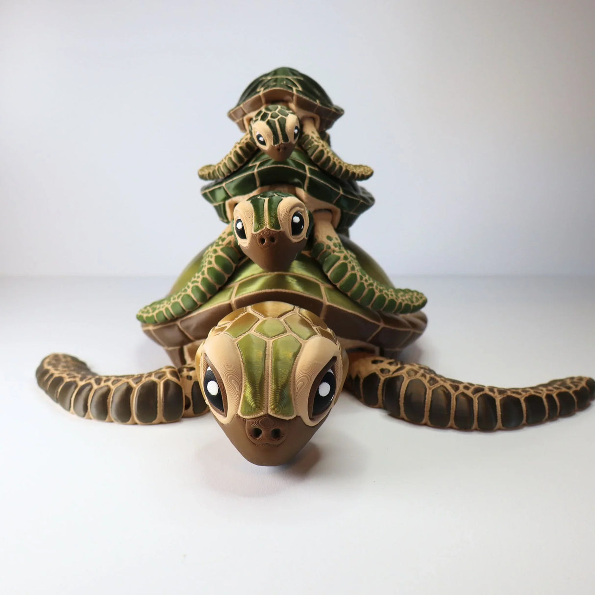 Stacked 3D printed sea turtle sensory toys with detailed green shells on white background.