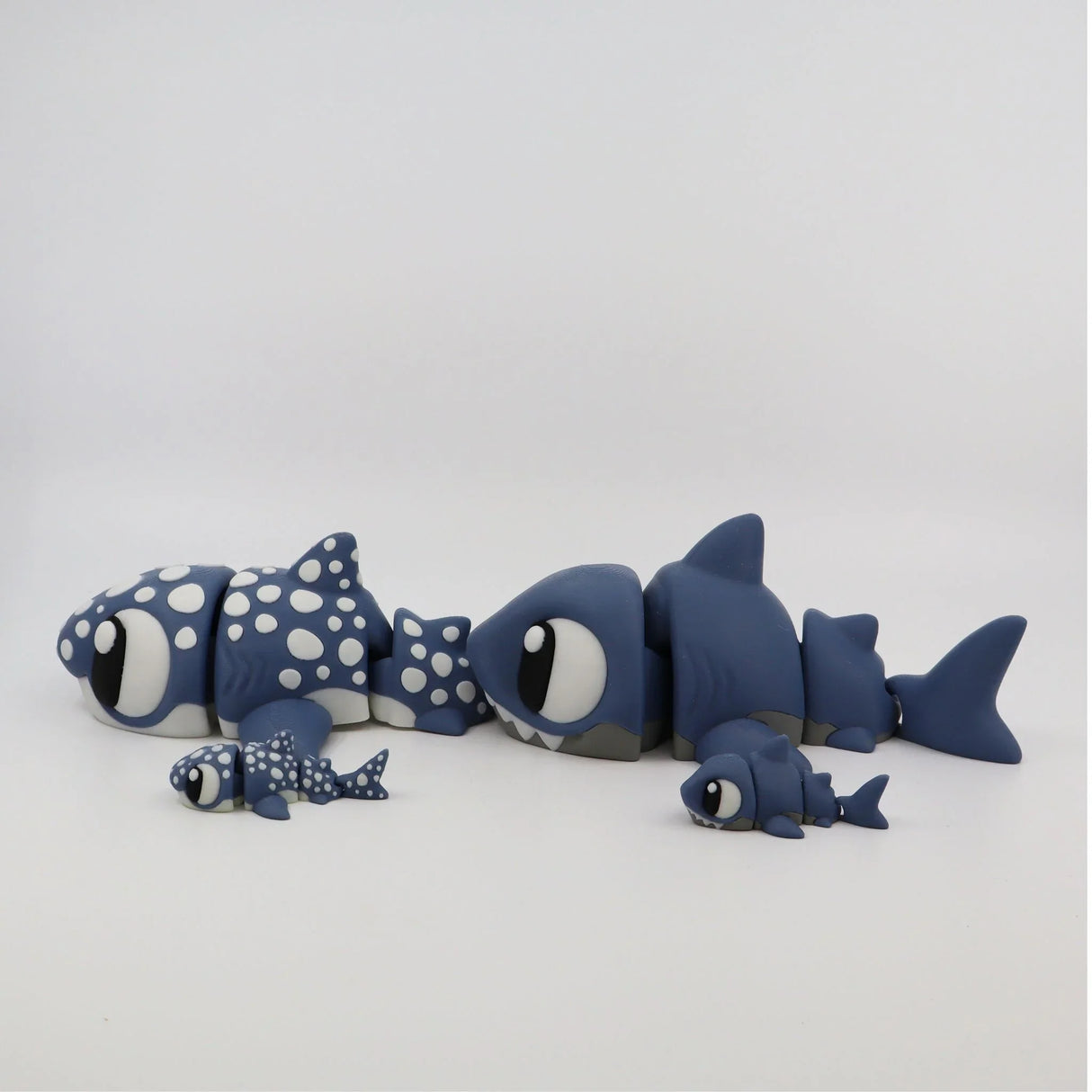 Blue 3D printed sensory shark toys in different sizes with dotted and smooth designs on white background