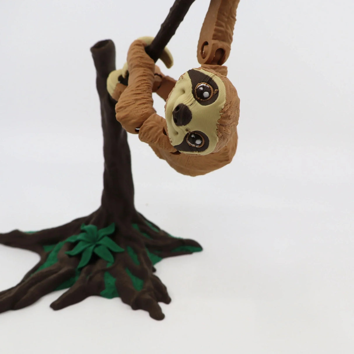 3D printed sloth sensory toy hanging from tree branch, brown and green, educational toy