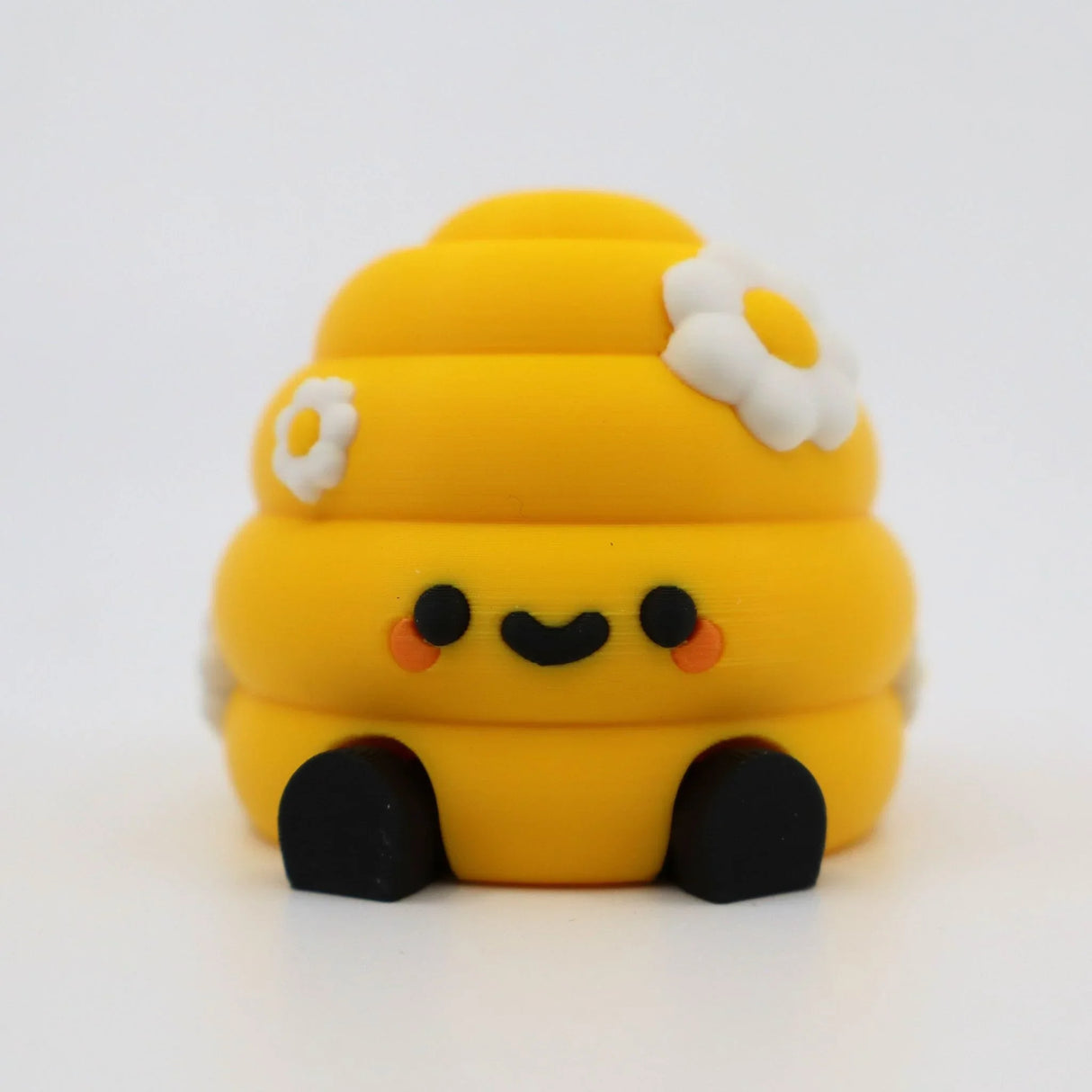 Yellow 3D printed fidget toy with daisy flowers, cute smile, and black feet for sensory play