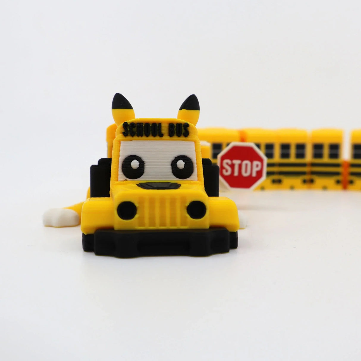 Cute 3D printed yellow school bus fidget toy with Pikachu ears and stop sign, sensory friendly design