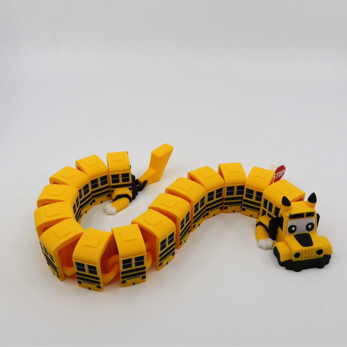 Yellow 3D printed school bus fidget toy with flexible segments and stop sign for sensory play