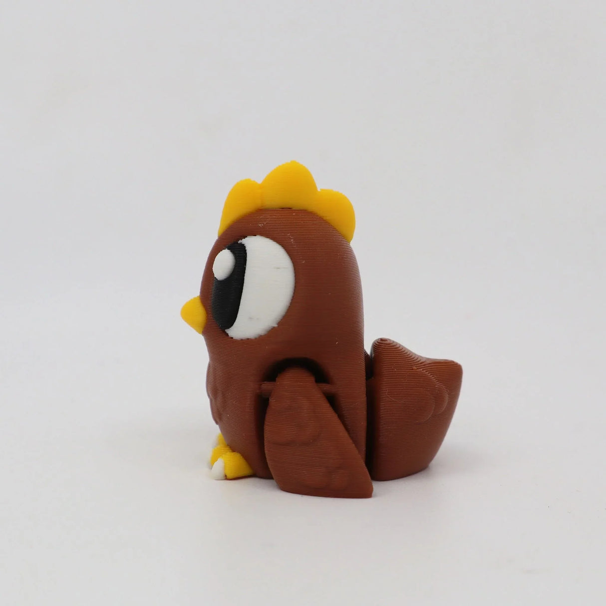 Brown 3D printed sensory chicken toy with yellow details on a white background