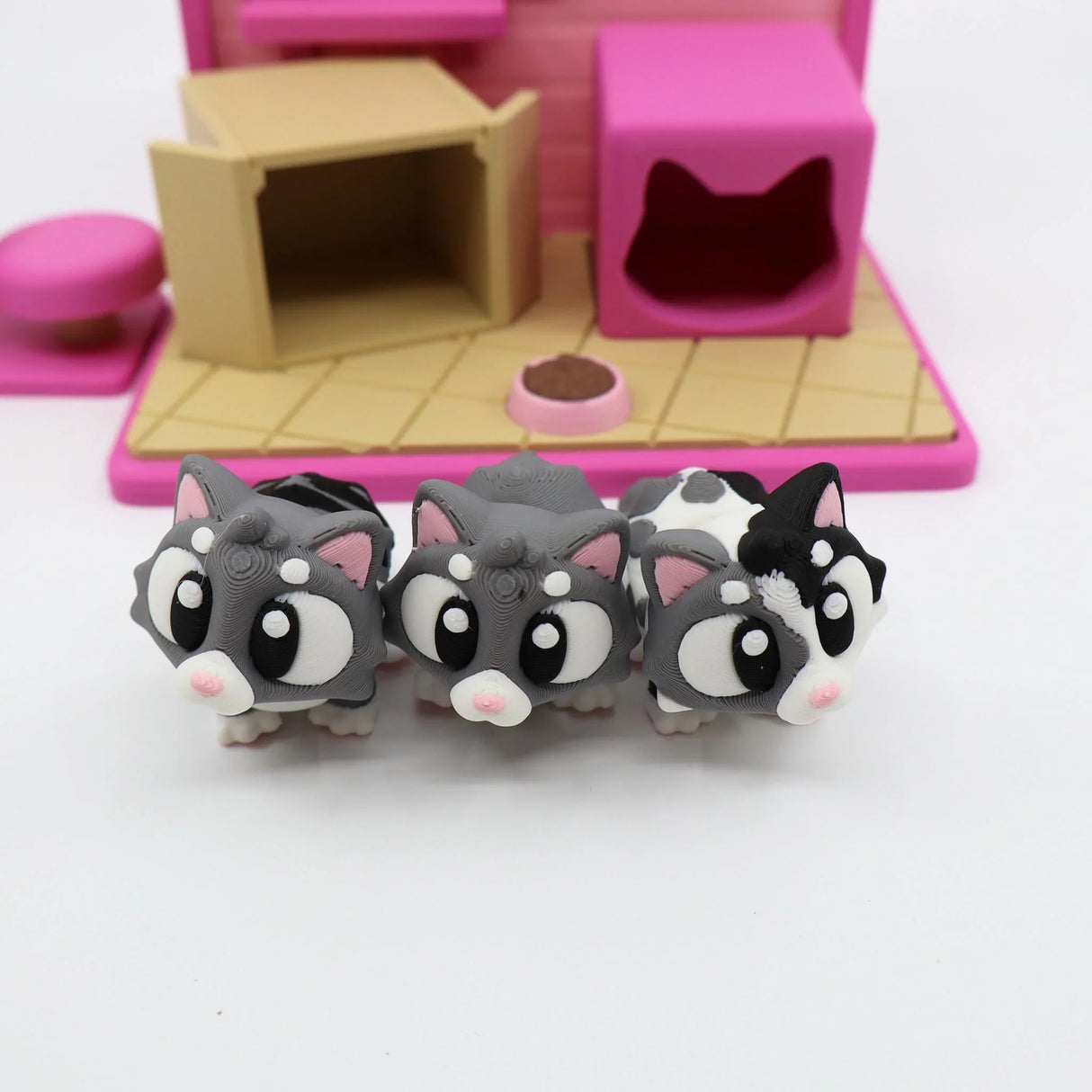 3D printed sensory toy kittens in front of a colorful pink and tan cat playset