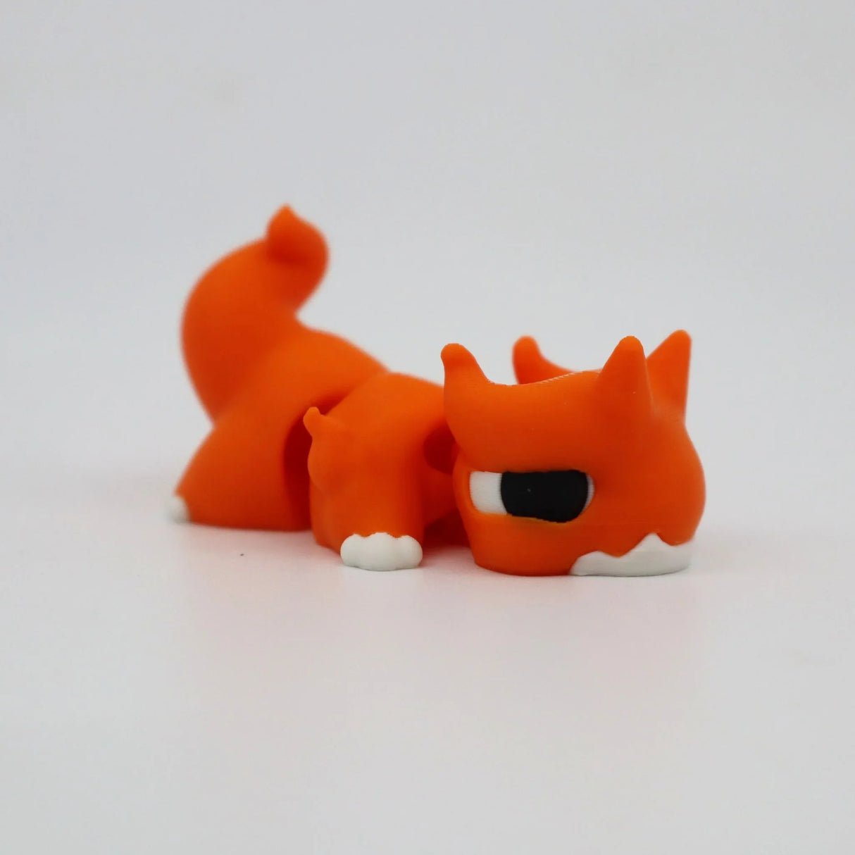 Orange 3D printed fox fidget toy with white paws and big eyes, sensory-friendly design for kids