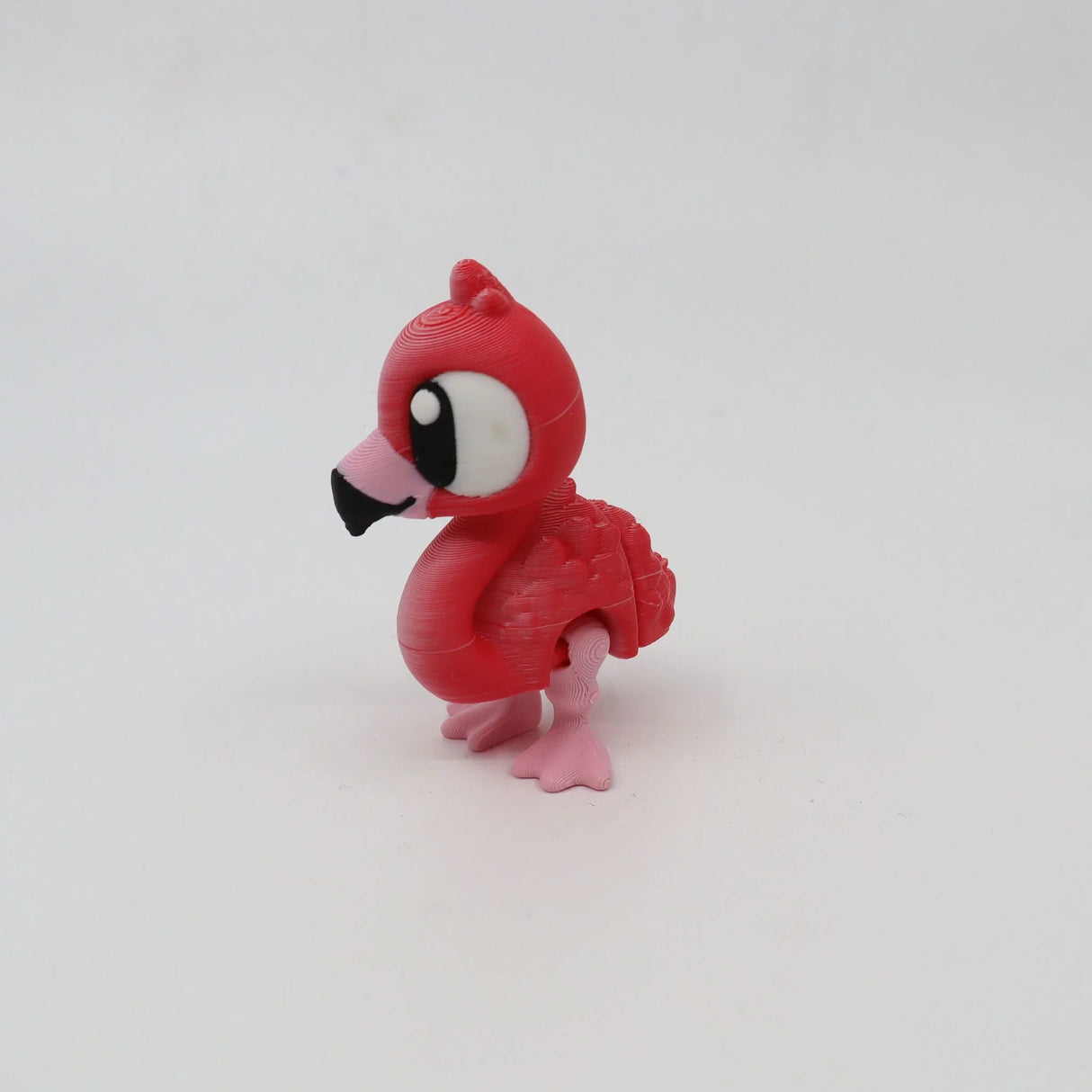 3D printed pink flamingo sensory toy with large eyes on a white background