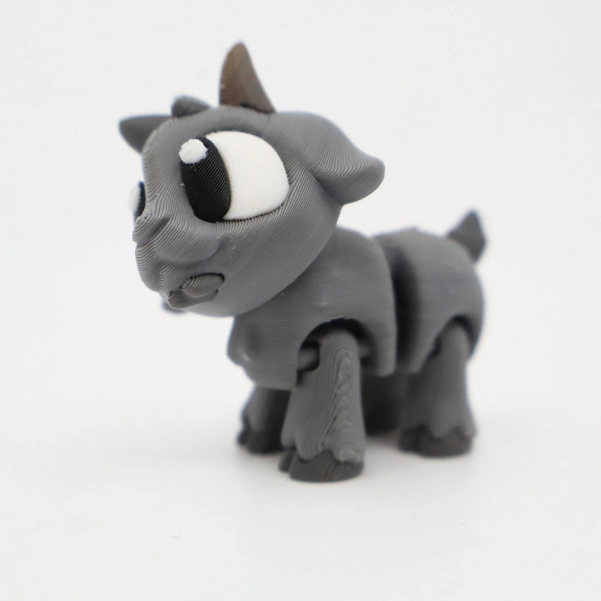 Gray 3D printed goat sensory toy with large eyes, designed for kids' tactile play and learning.