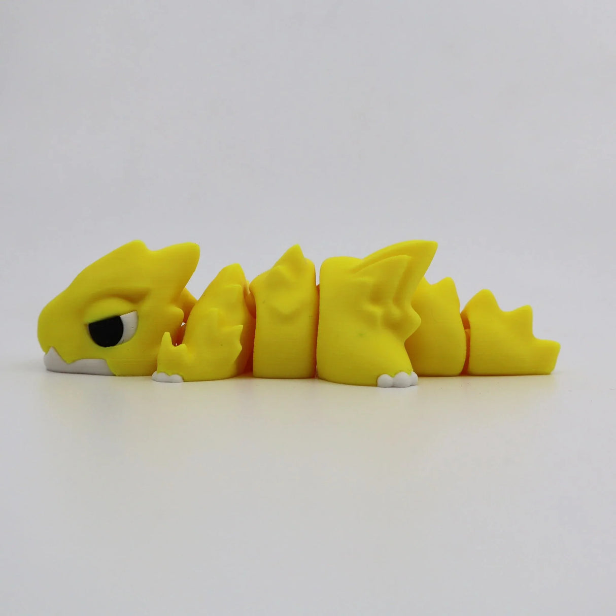 Yellow 3D printed flexi dragon fidget toy for sensory play and tactile stimulation