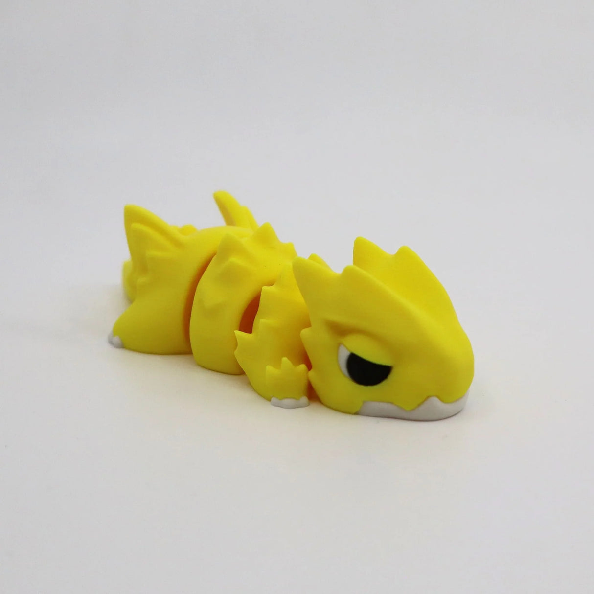 Bright yellow 3D printed flexi dragon fidget toy for sensory play and stress relief