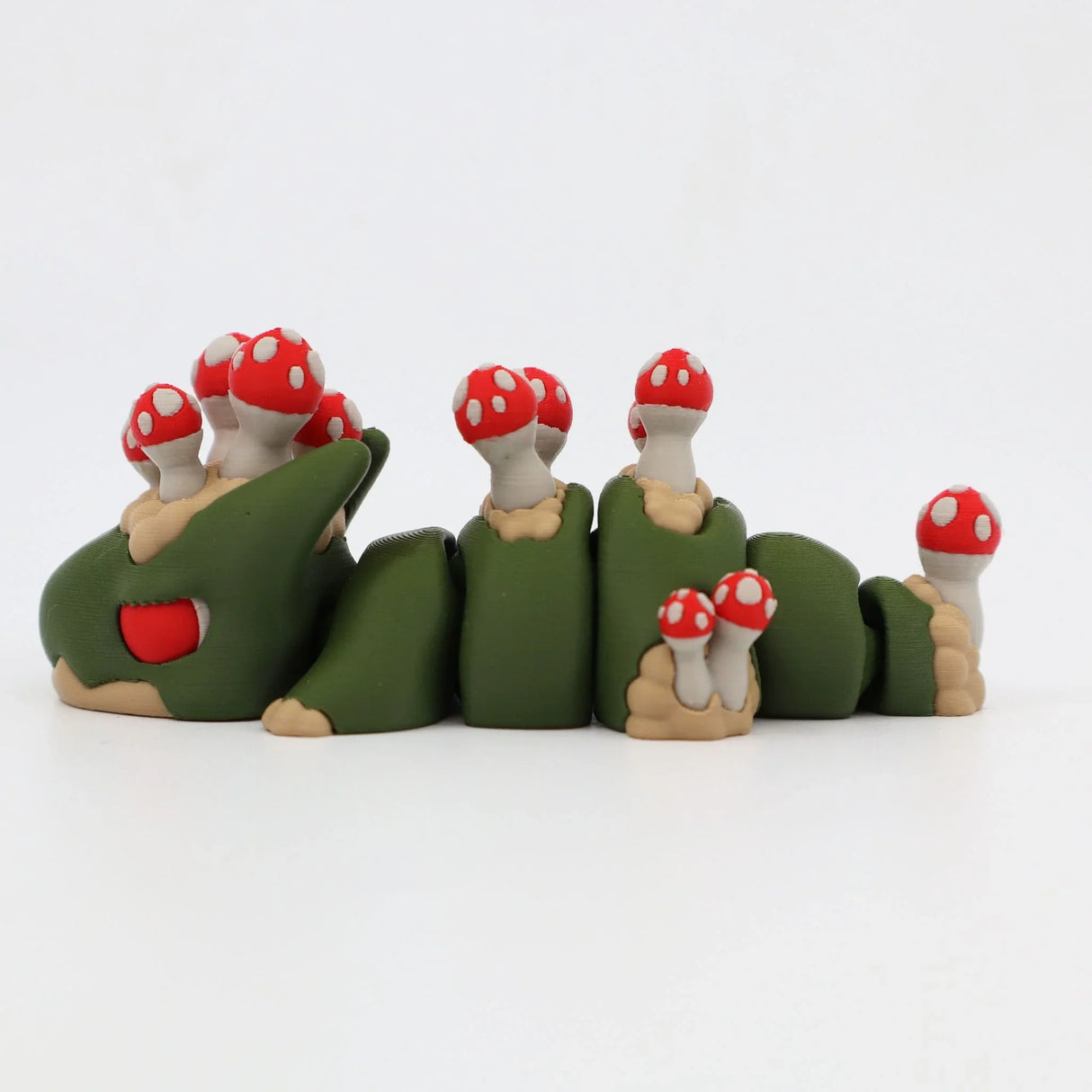 Green 3D printed sensory caterpillar toy with red spotted mushrooms on its back