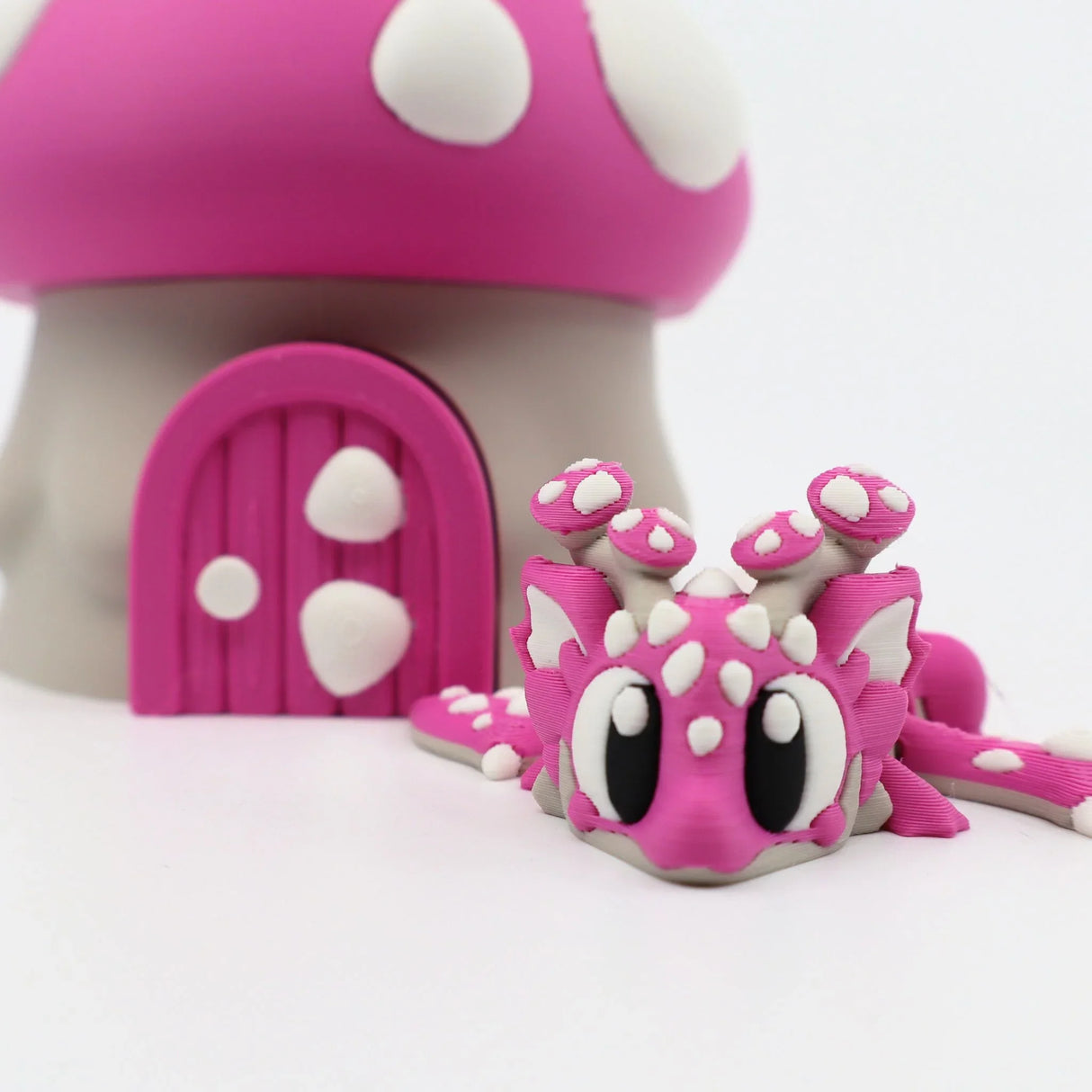 Pink 3D printed flexi dragon toy with mushroom house, sensory fidget for kids