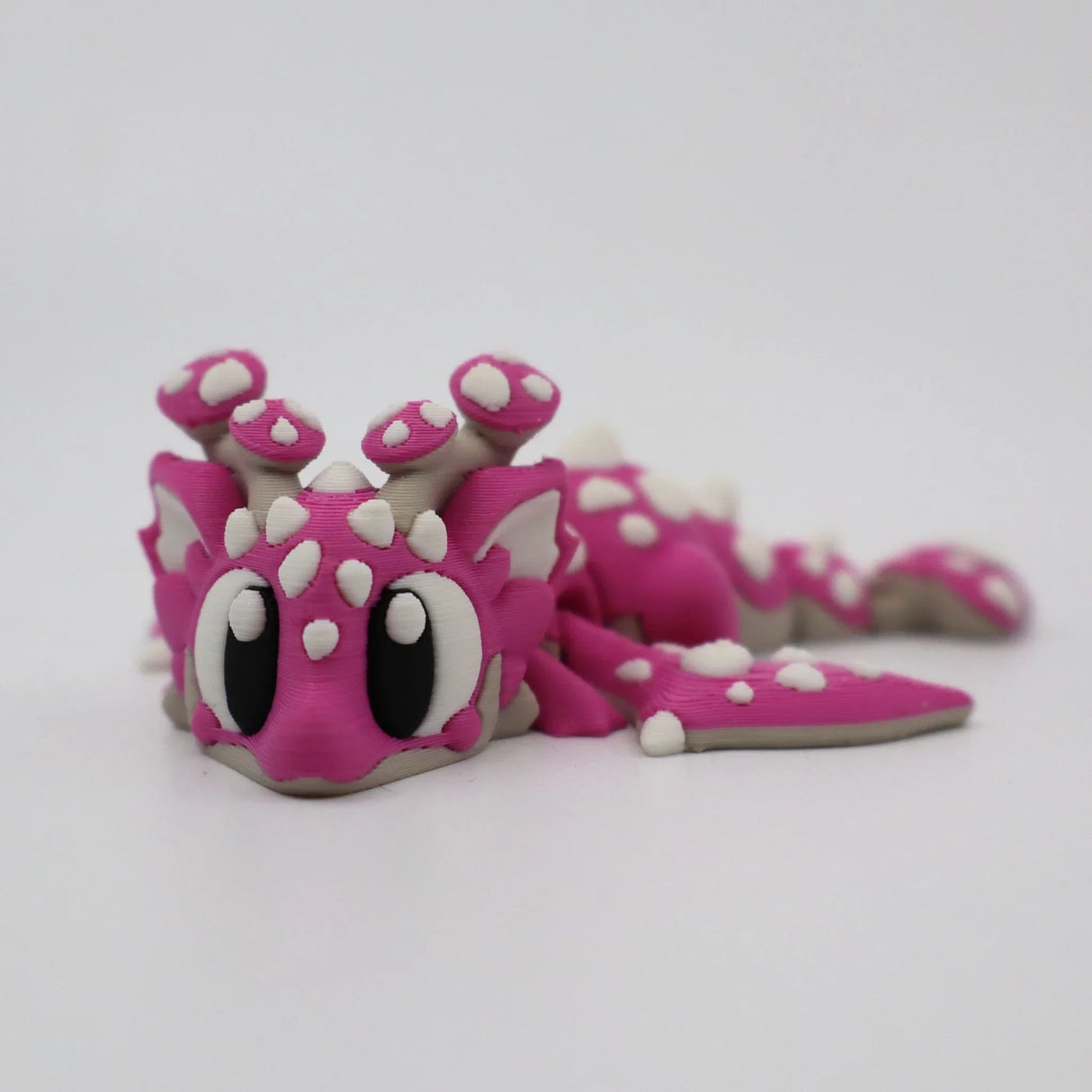 Pink 3D printed flexi dragon toy with white spots, sensory fidget for kids