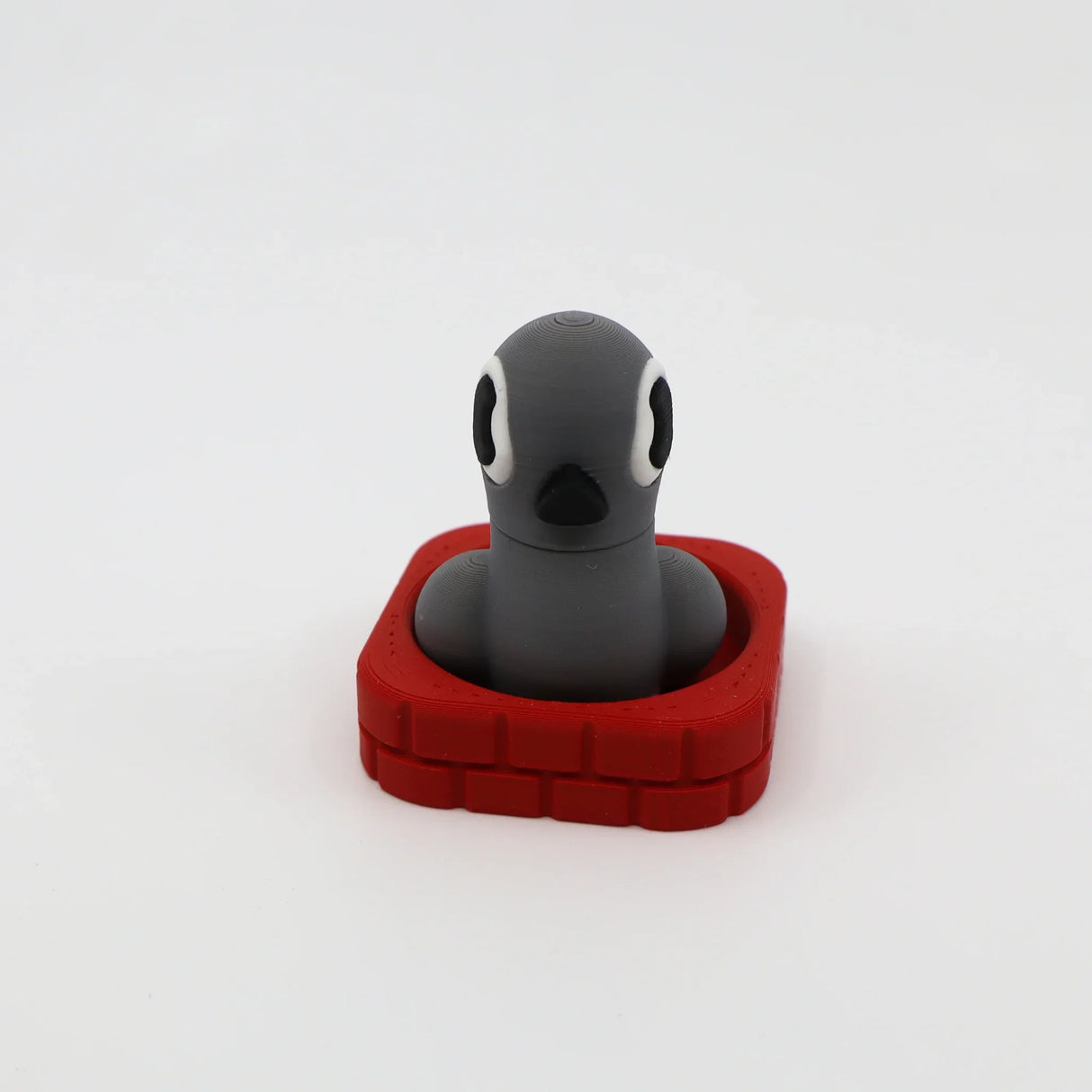 3D printed gray penguin fidget toy in red base, sensory-friendly design for kids