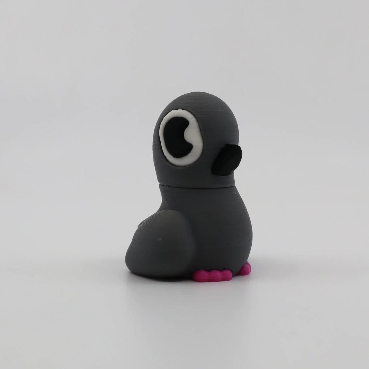 Gray 3D printed penguin fidget toy with pink feet, sensory-friendly design for kids