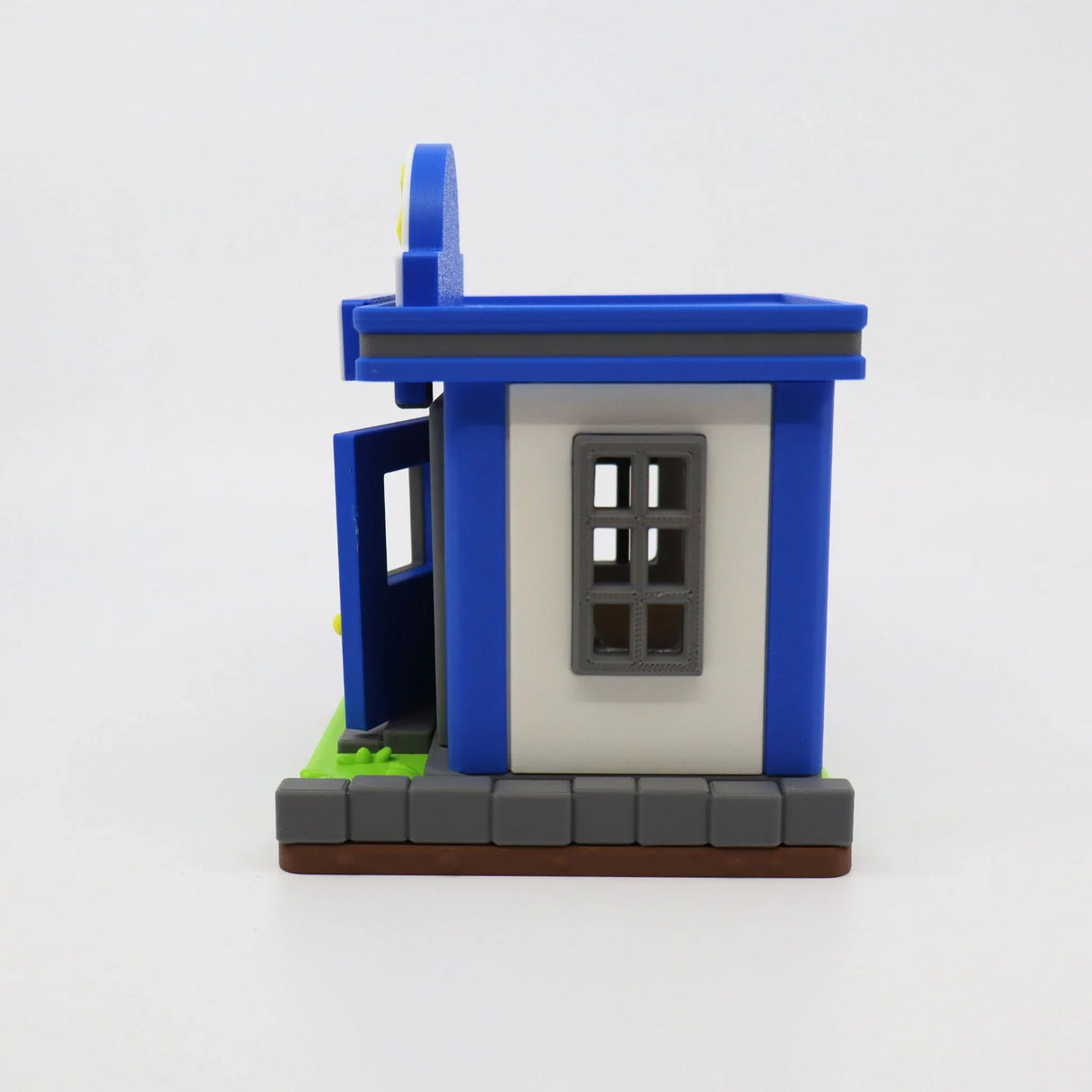Blue and white 3D printed sensory toy house with open door, gray window, and green base for tactile play