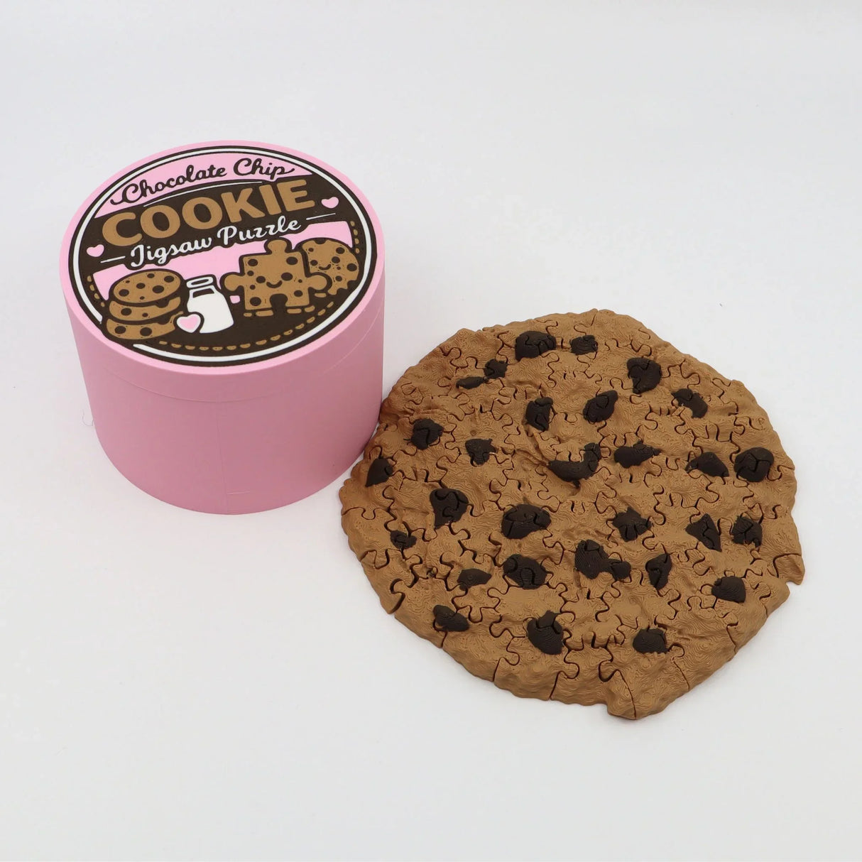 Chocolate chip cookie jigsaw puzzle with pink round box packaging on white background