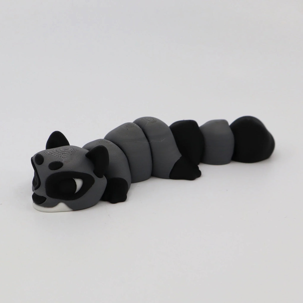 Gray and black 3D printed raccoon fidget sensory toy with segmented body on white background