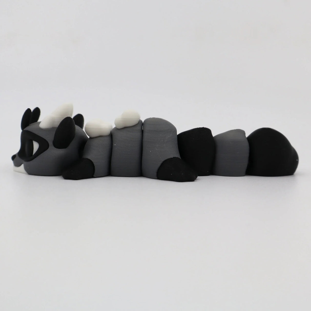Gray and black 3D printed raccoon flexi sensory toy for kids on white background