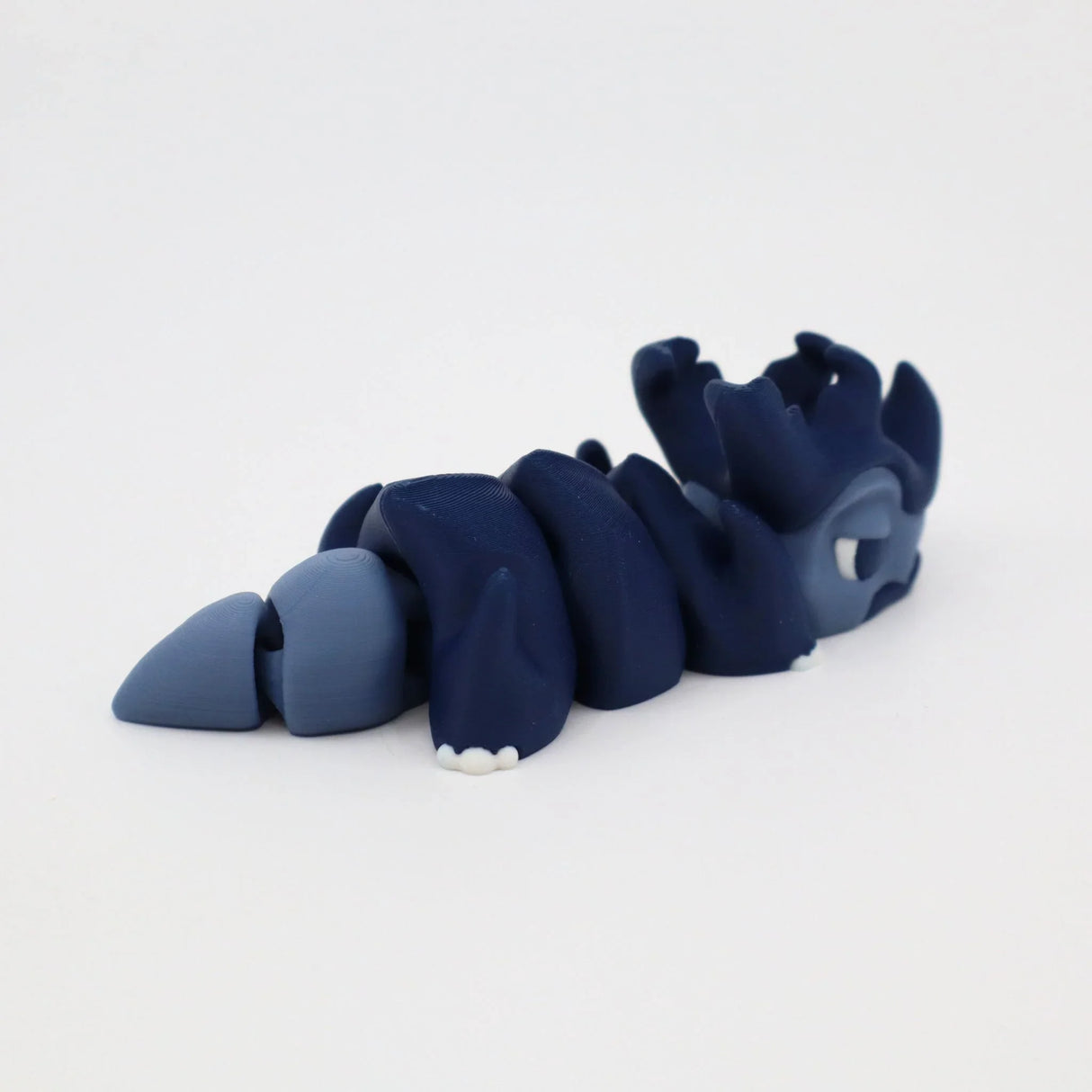Blue 3D printed articulated sensory toy in the shape of a segmented sea creature on white background