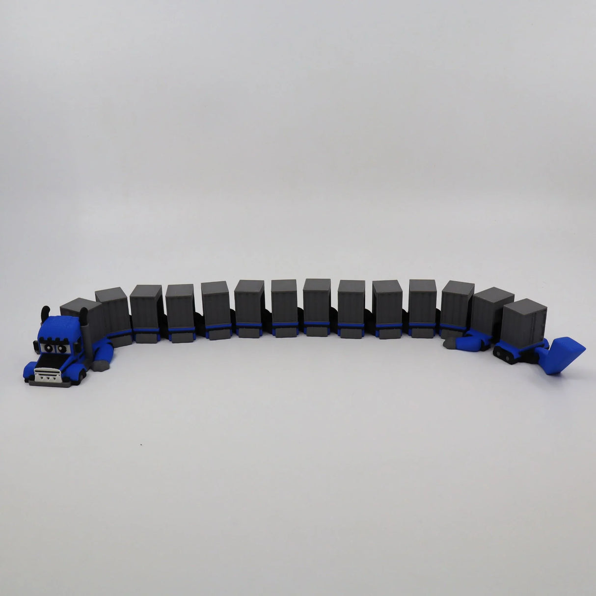 Blue 3D printed flexible truck toy with gray cargo trailers, sensory fidget for kids