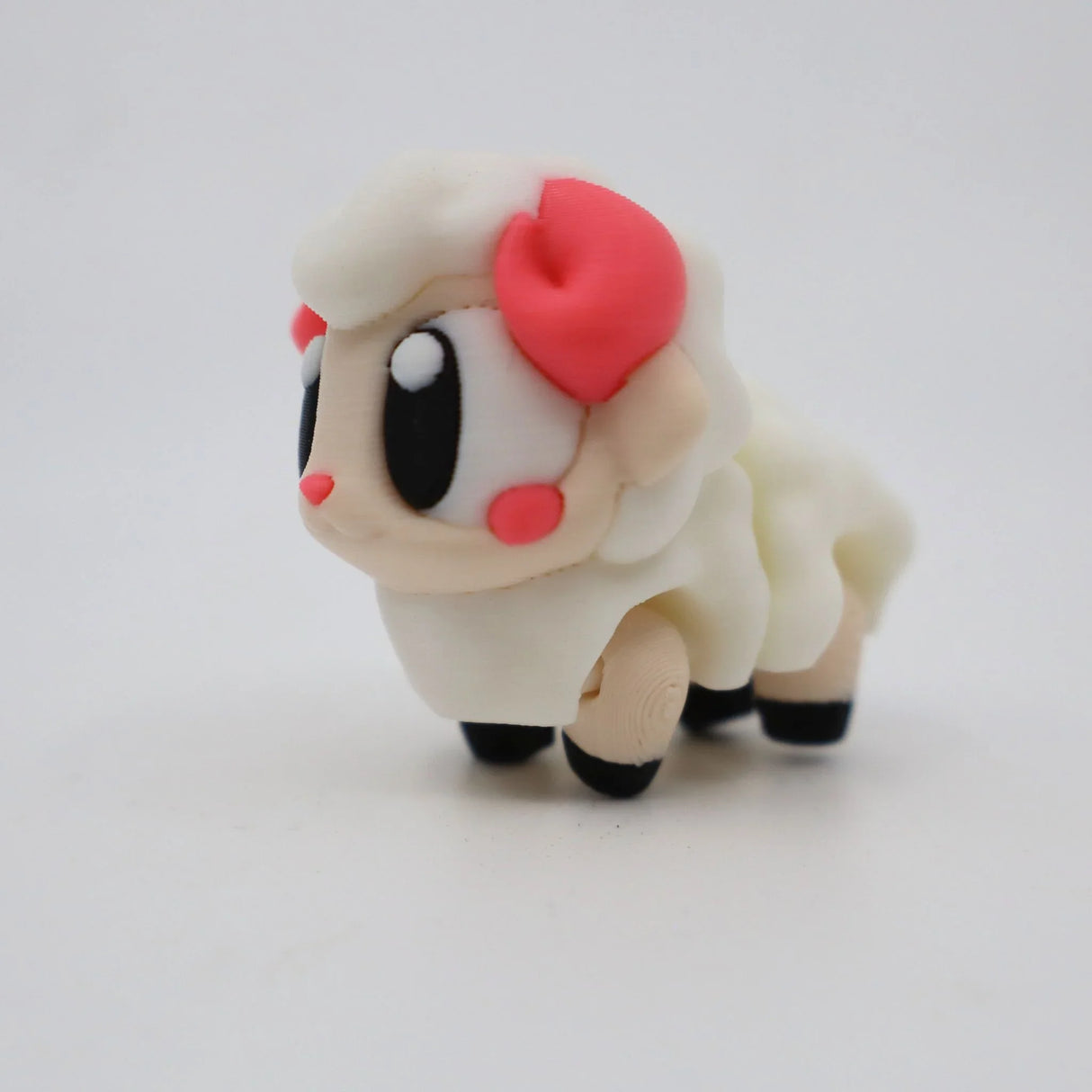 Cute 3D printed sheep sensory toy with big eyes and pink accents on a white background