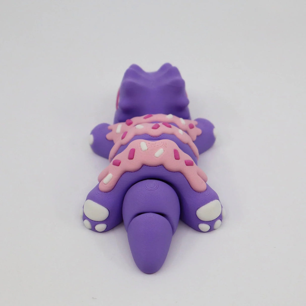 Purple dinosaur sensory toy with pink frosted sprinkles, 3D printed fidget figure