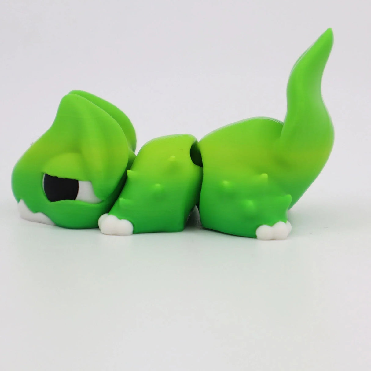 Green 3D printed sensory toy lizard with articulated tail on white background
