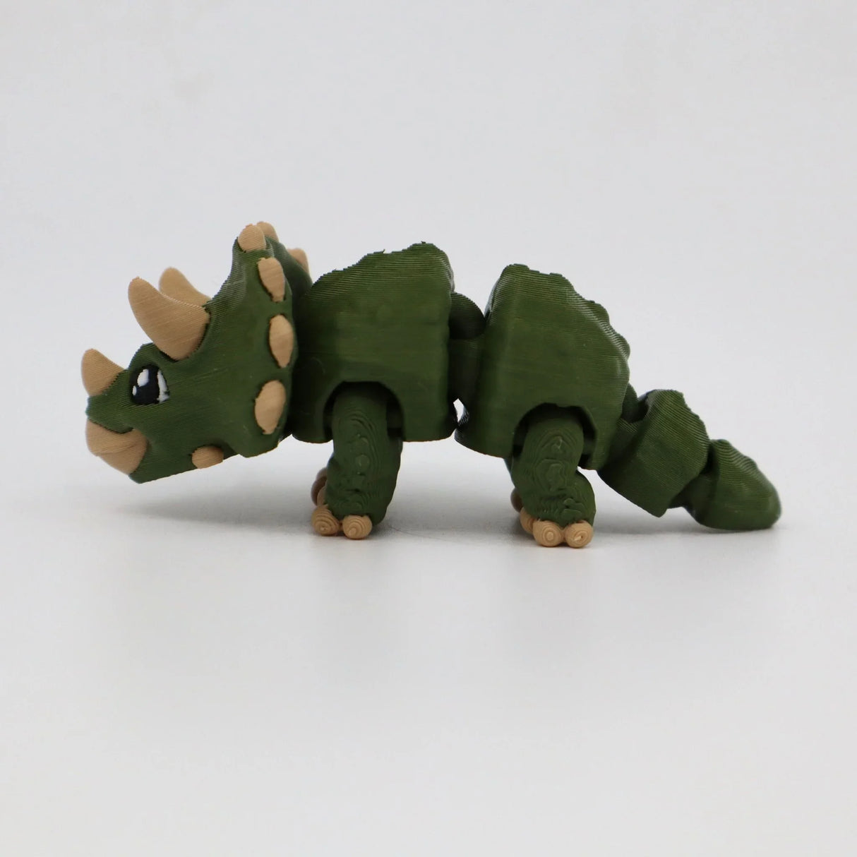 Green 3D printed triceratops sensory toy with flexible joints on white background