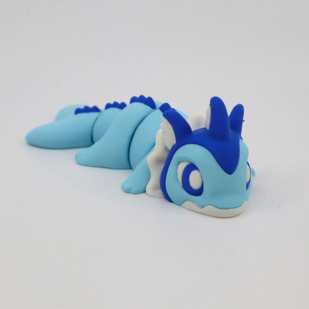 Blue and white 3D printed flexible sensory dragon toy on a white background.