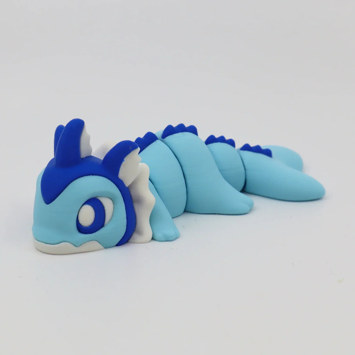 Blue and white 3D printed sensory toy in the shape of a cute dragon with segmented body